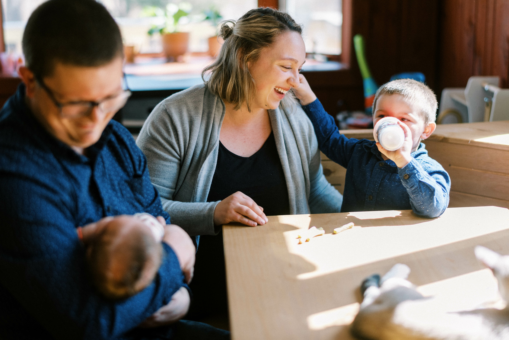 Barnefamilie som sitter ved frokostbordet i en hyggelig morgenstemning.